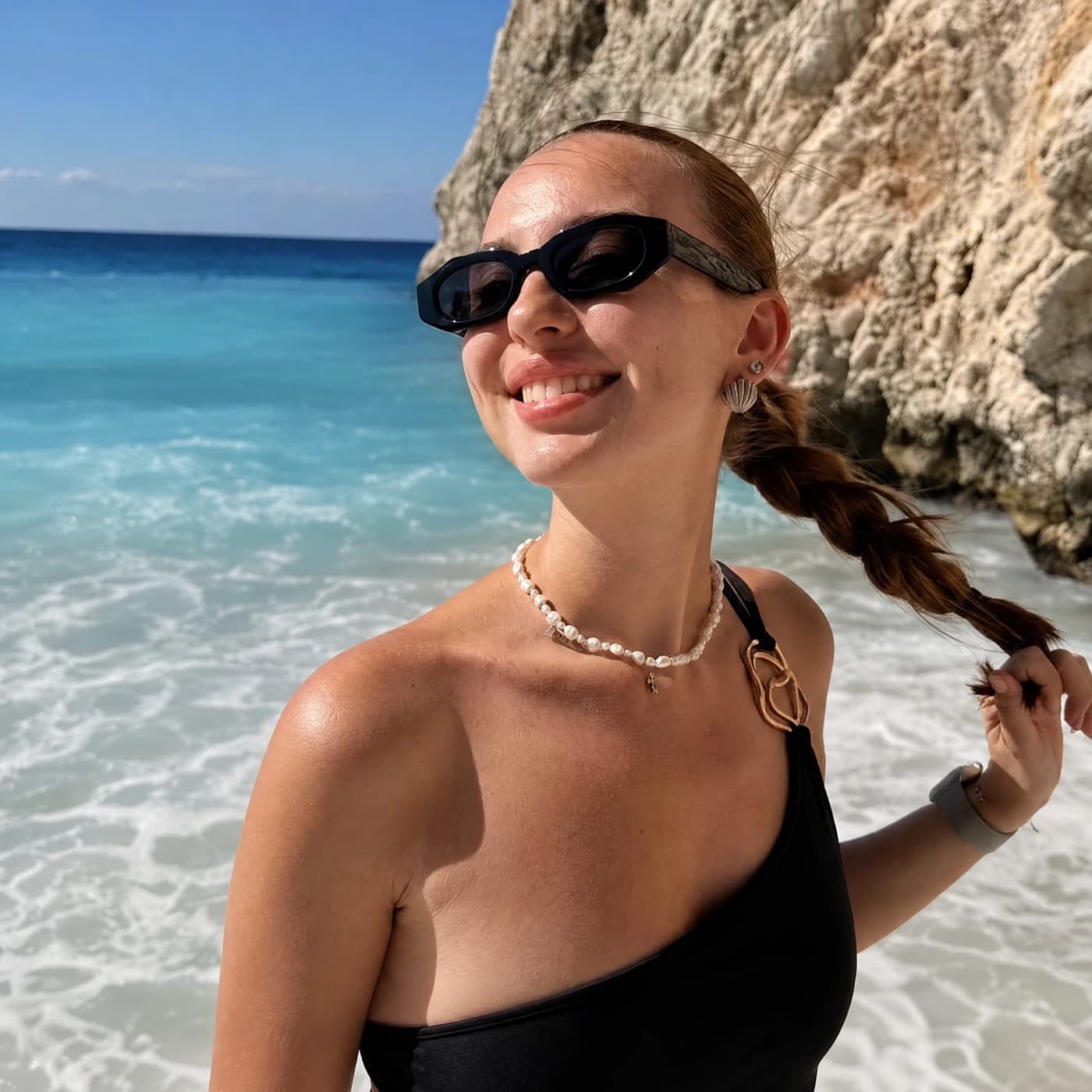A woman in sunglasses on a beach, original photo